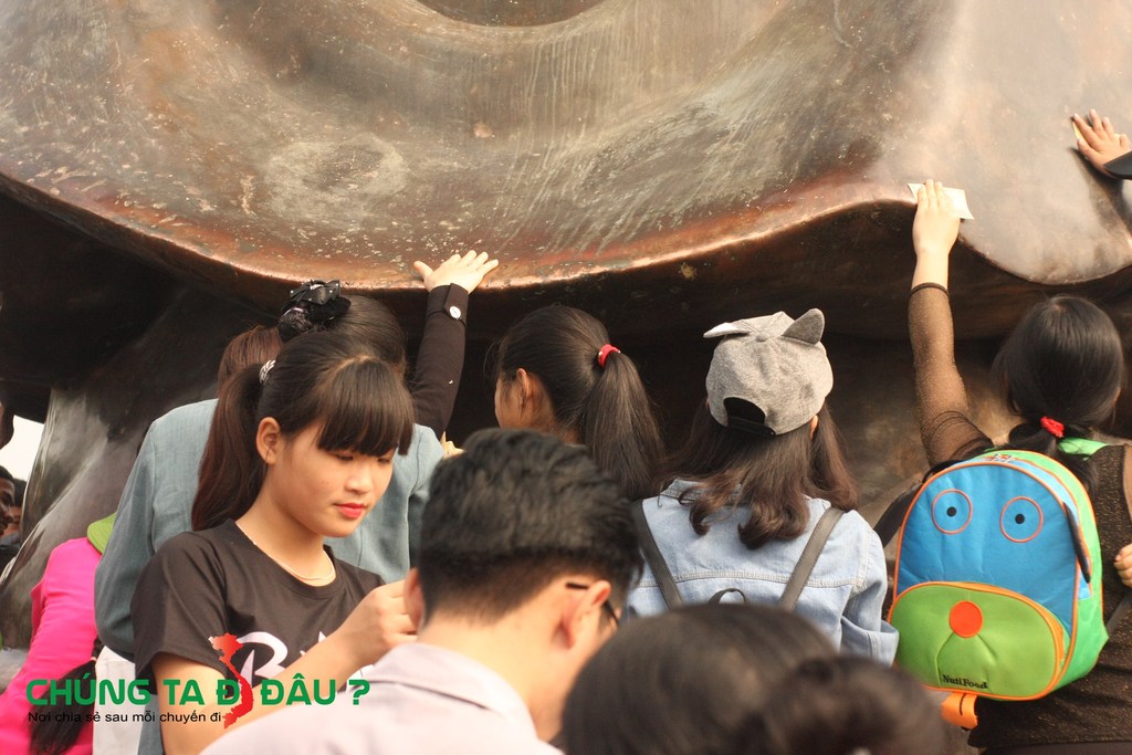 Những người đi lễ chà tiền vào tượng phật để lấy may