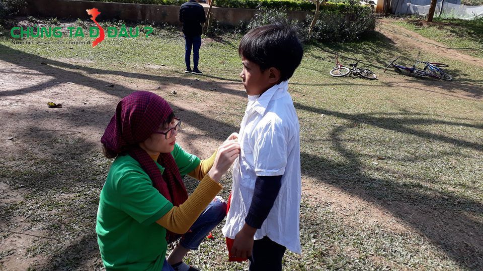 TNV mặc thử áo cho một em học sinh